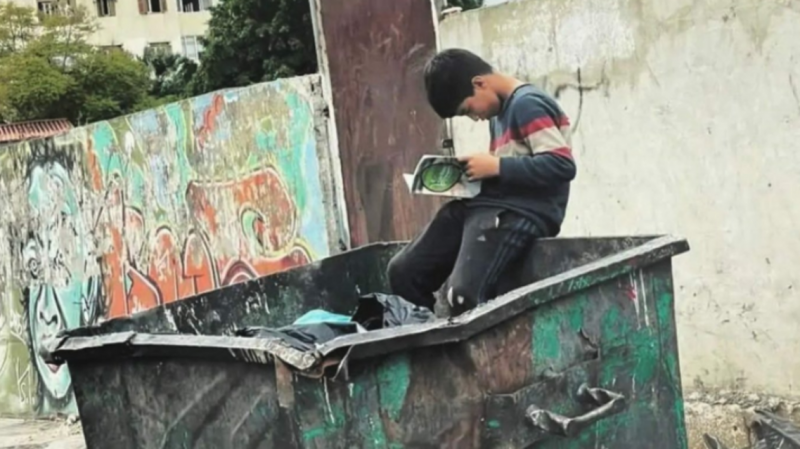 In Lebanon: Photo of a Child Reading a Book in a Trash Container Sparks Social Media Outrage