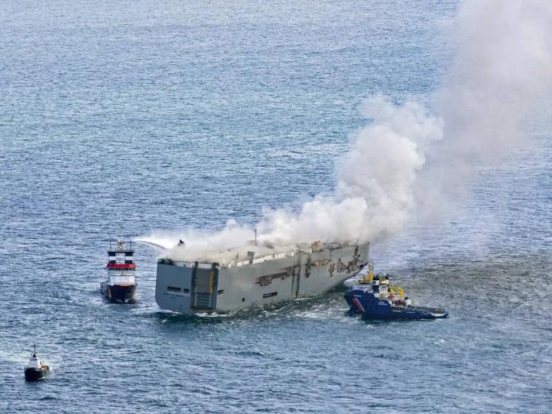 Title: Dutch Authorities Tow Burning Cargo Ship to Port