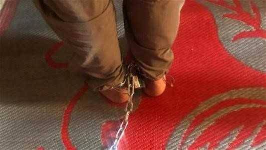 Father Binds Son with Iron Chain