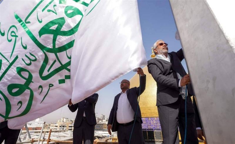 Title: Raising the Flag of Eid al-Ghadir in the Imam Ali Courtyard
