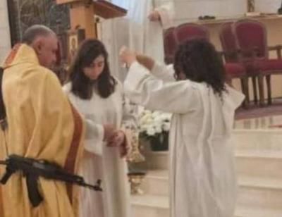 بالفيديو.. كاهن يحمل سلاحاً في قداس الميلاد!